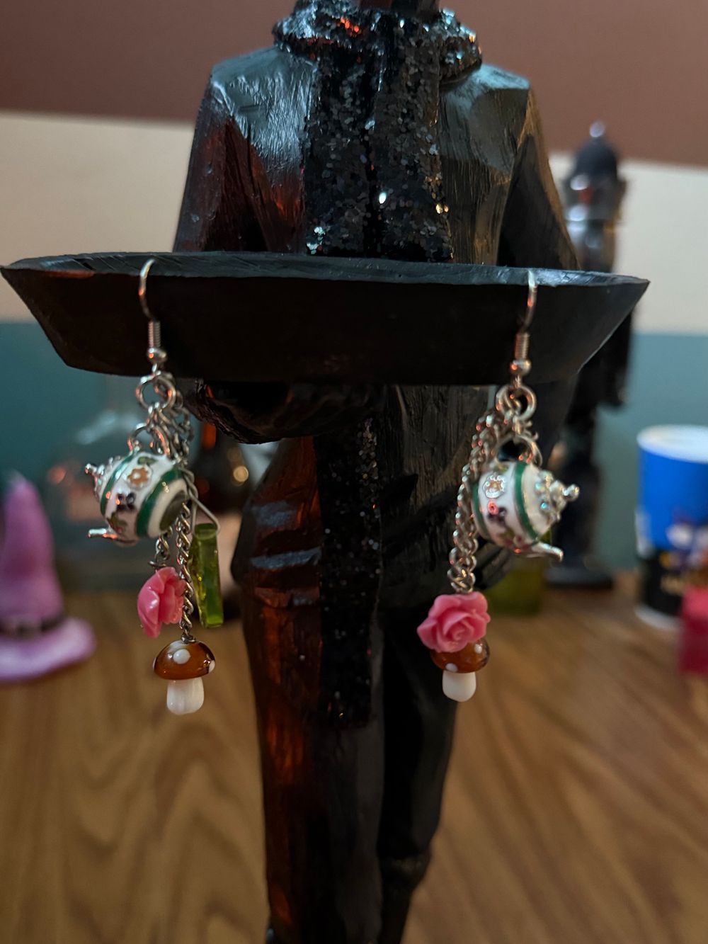 Earrings hanging from a humanoid statue with a deer head.